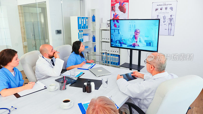 Team of medical staff during video conference with doctor in hospital